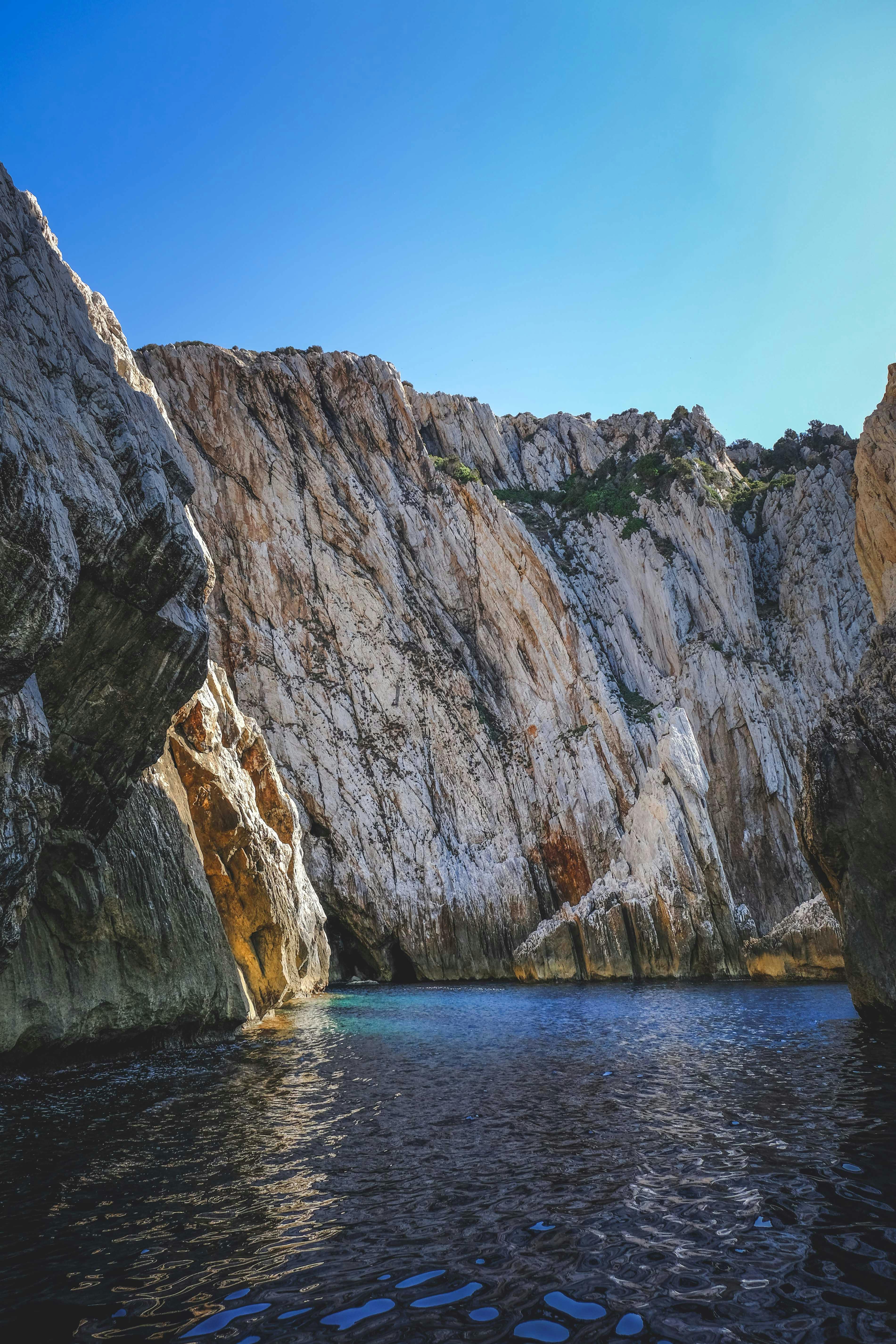 tall bare cliffs over narrow mountain river in ravine