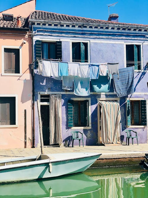 Townhouse with Hanging Laundry by a Canal, and a Canoe Moored 