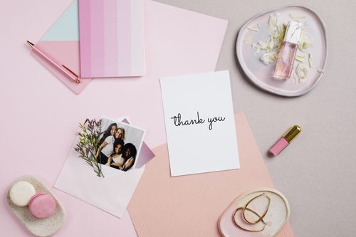 Free A stylish flat lay featuring a thank you card, perfume, and pink stationery on a soft pastel background. Stock Photo