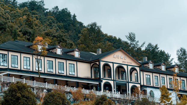 Charming mansion facade surrounded by lush forest, featuring classic architecture and peaceful ambiance.
