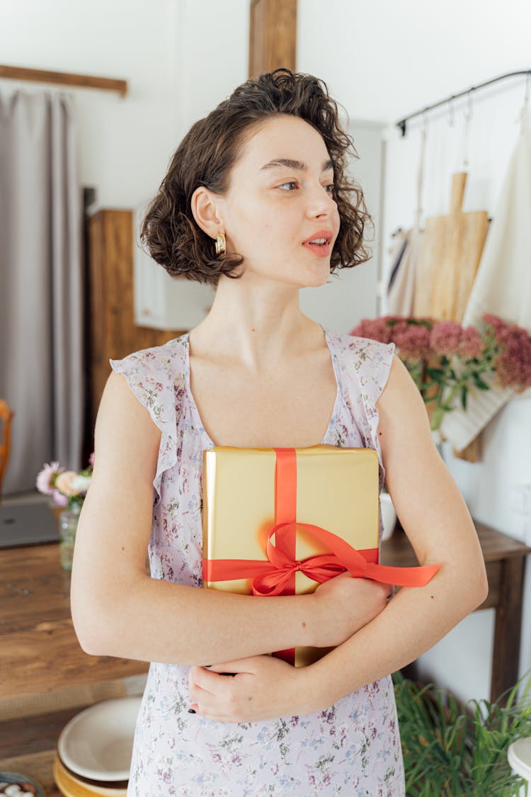 Woman In Floral Dress Holding A Gift Box