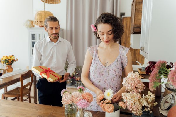 Hosts arranging flowers and gifts before the party