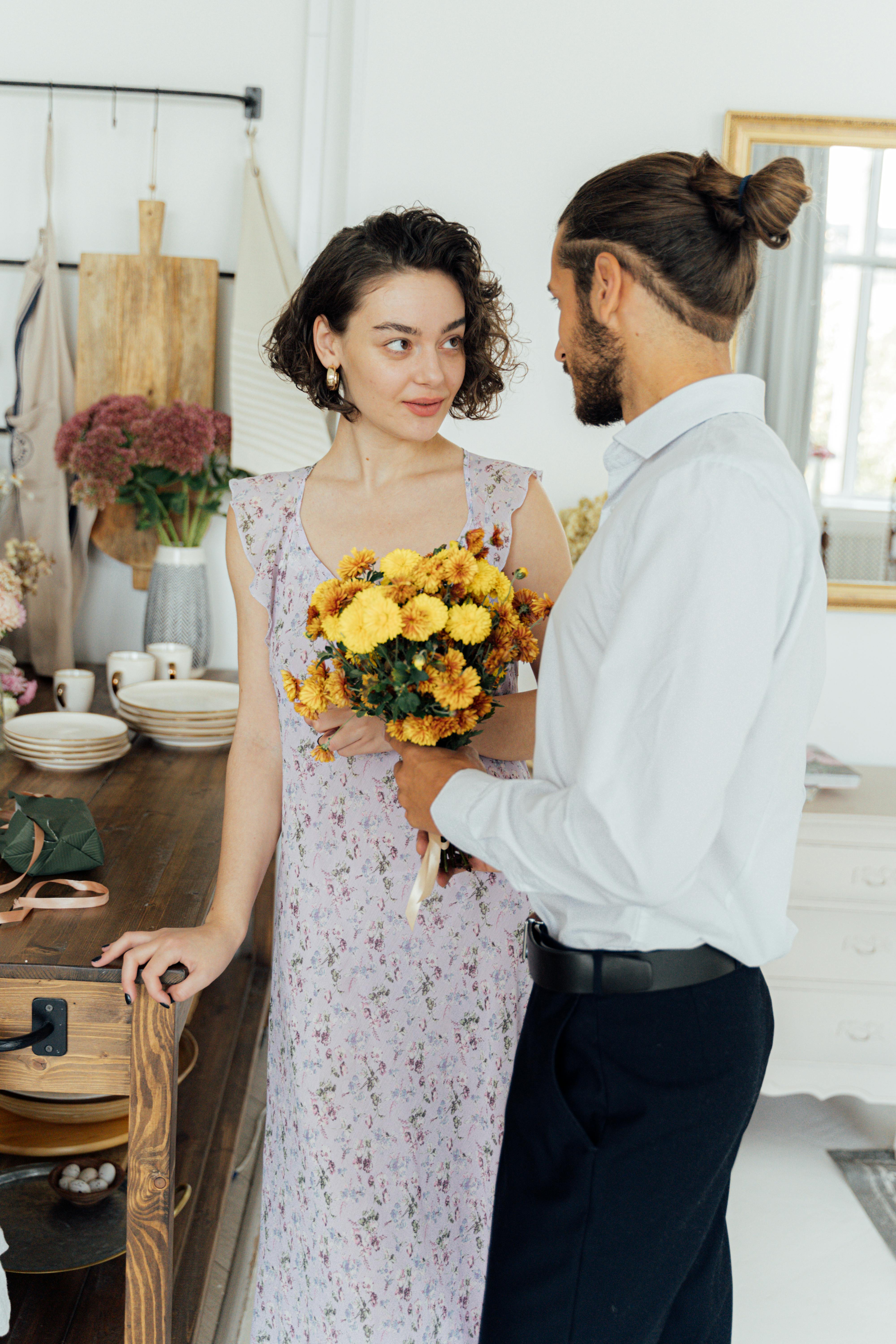 一对夫妇在舒适的厨房里，与一束鲜花共享了一个充满爱意的时刻