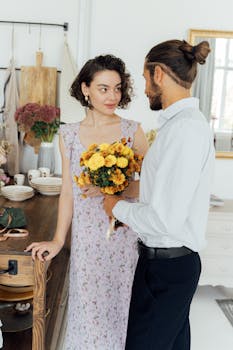 一对夫妇在舒适的厨房里，与一束鲜花共享了一个充满爱意的时刻