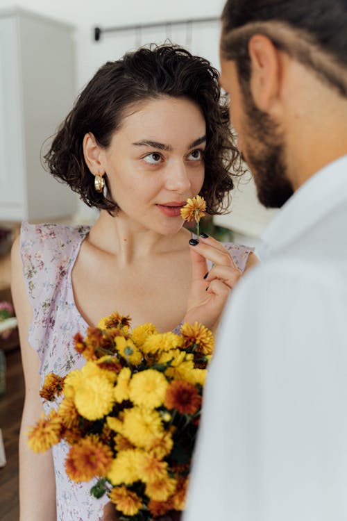 Free Man Holding Bouquet of Flowers in Front of a Woman Stock Photo