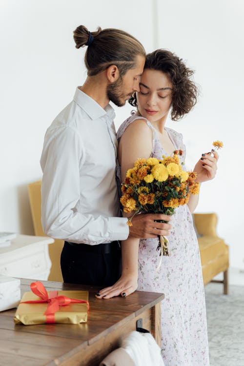 Man in White Dress Shirt Holding Bouquet of Flowers