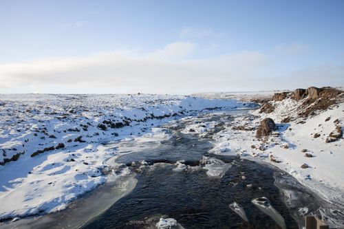 Free Breathtaking winter view of a snow-covered, frozen river in Iceland's tranquil landscape. Stock Photo