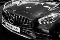 这张黑白照片细致展现了豪华车的前格栅与前灯，尽显优雅与时尚