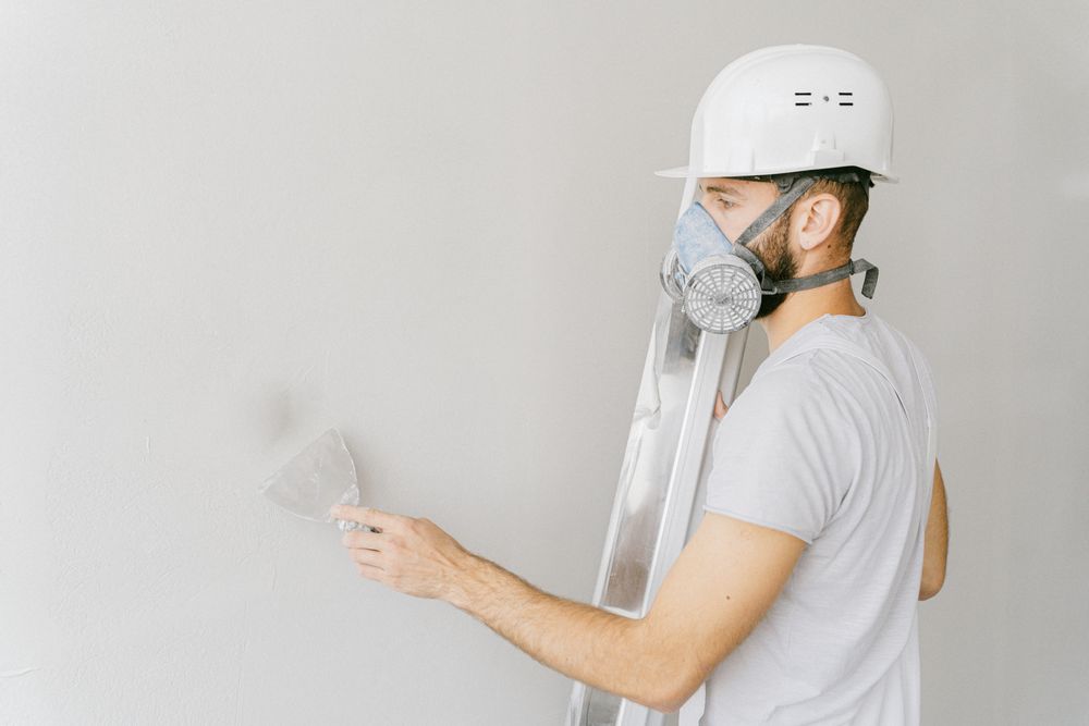 Worker applying plaster to an interior wall by hand