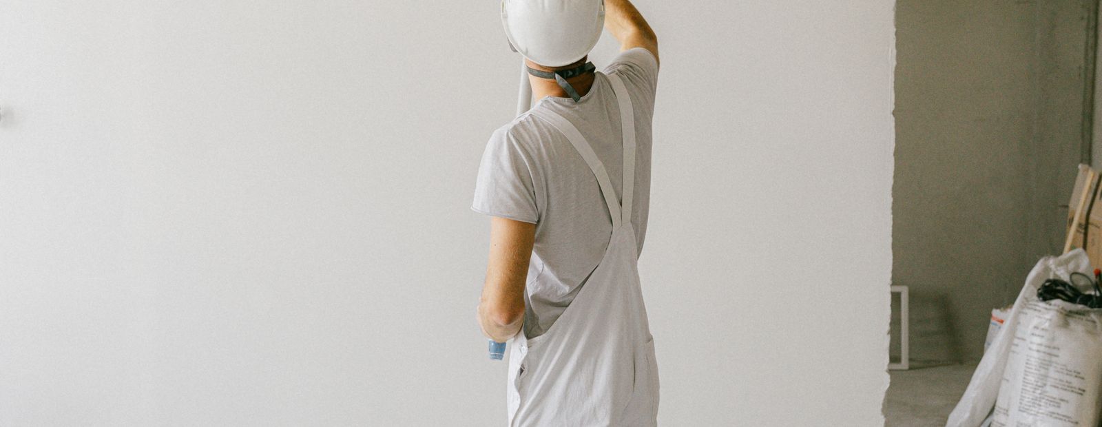 Person painting an interior wall with a paint roller