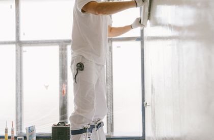Taper smoothing joint compound on a wall with a trowel, close crop, representative trade photo