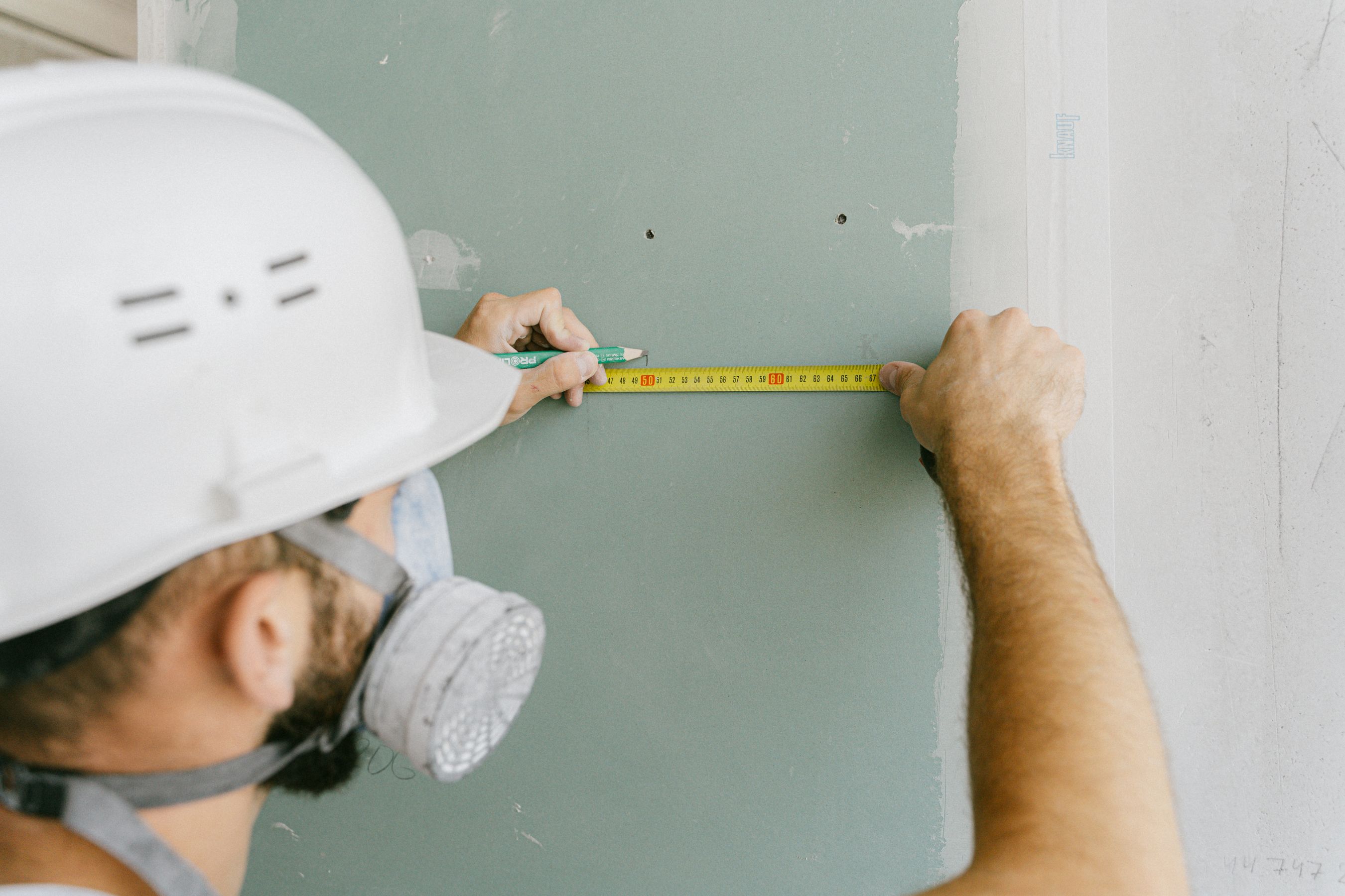 Measuring drywall sheet with tape