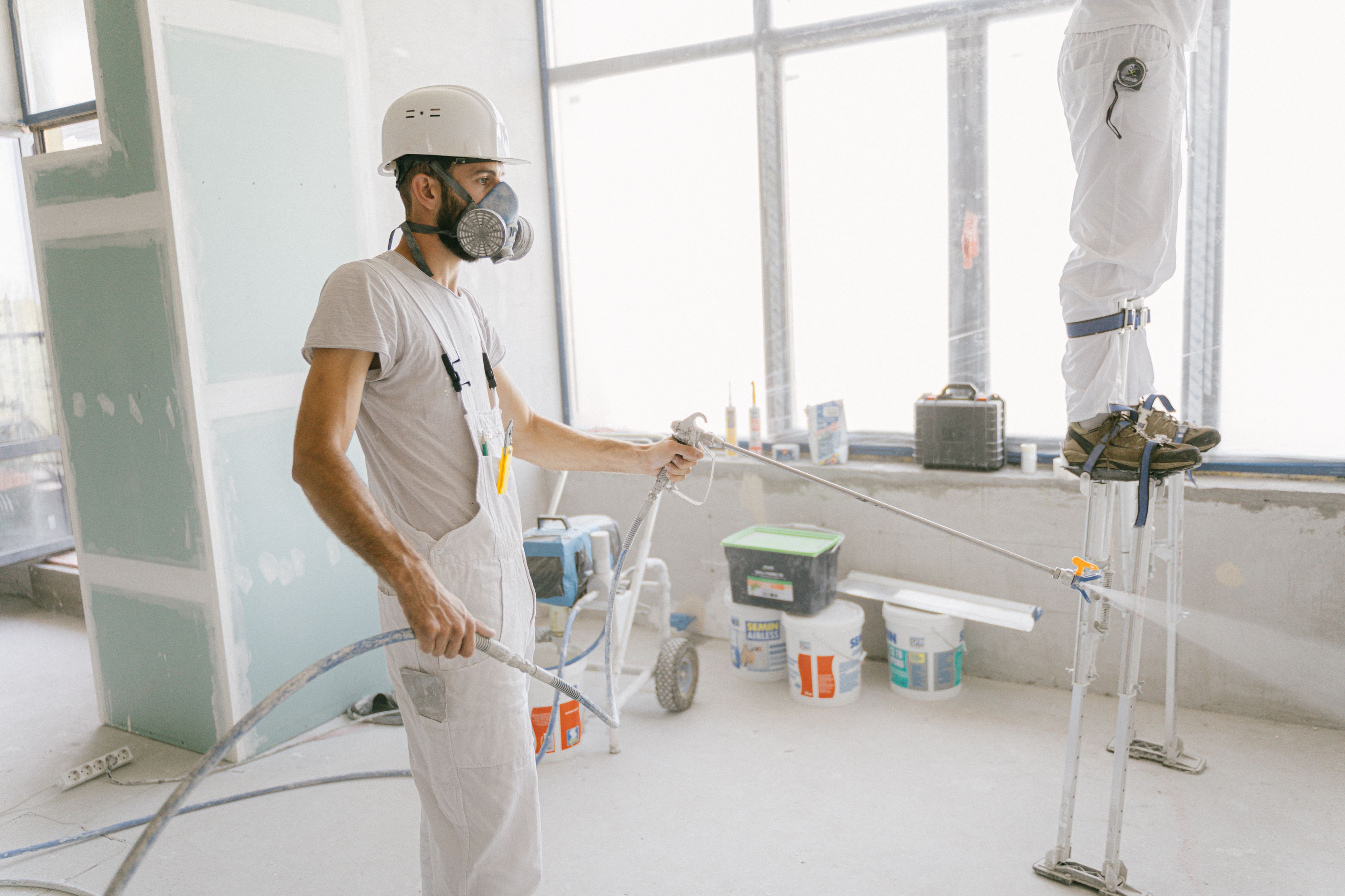 Interior painting crew spraying walls during renovation