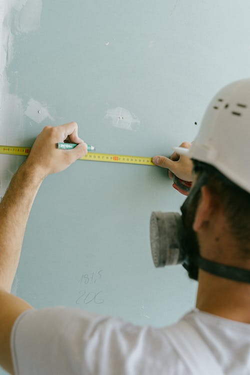 Free A Construction Worker Holding a Pencil and Measuring Tape Stock Photo