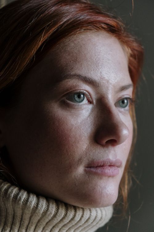 Free Close-up portrait of a caucasian redhead woman in a warm sweater looking thoughtful. Stock Photo