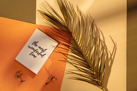 A Greeting Card beside a Palm Leaf