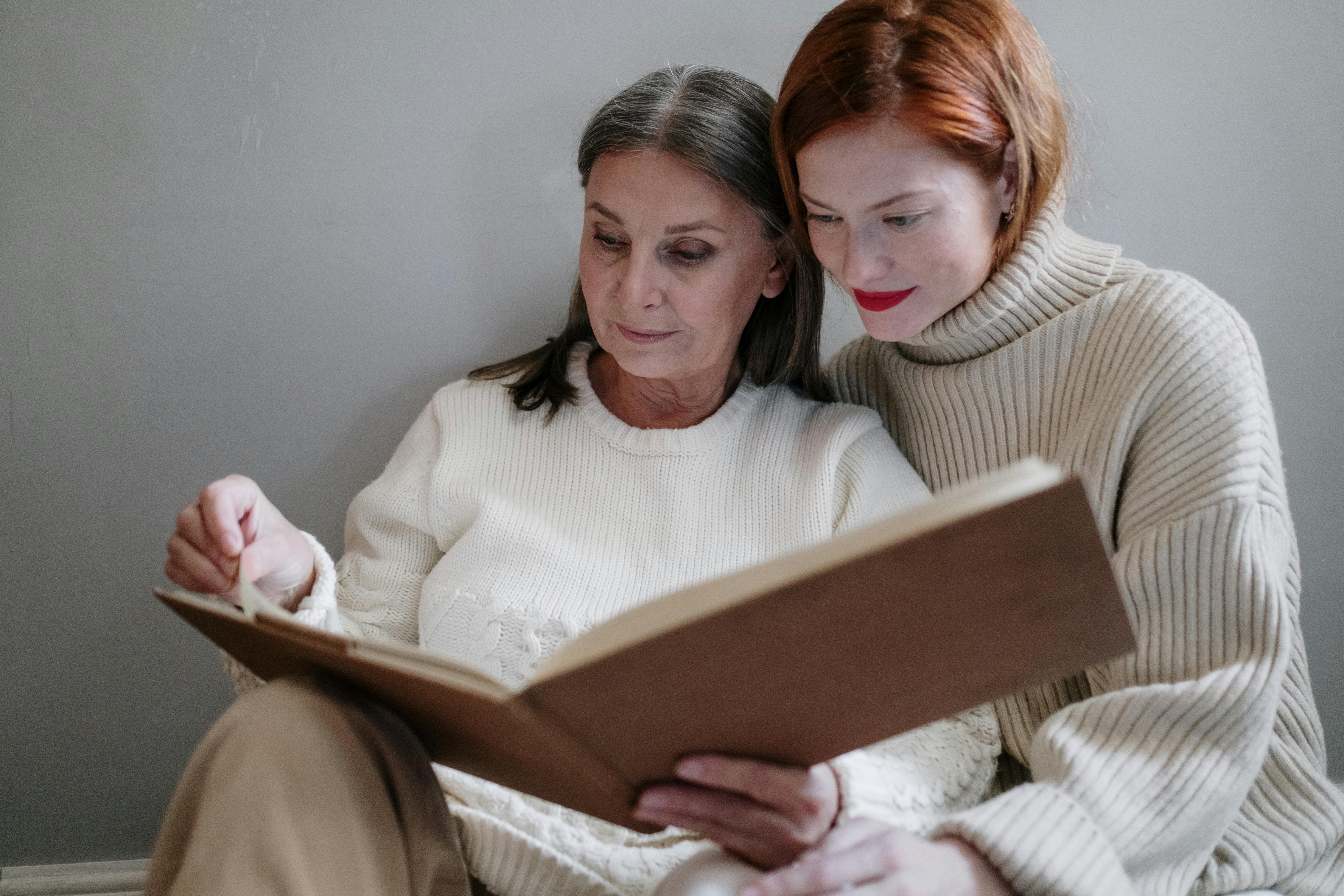 A heartwarming scene of a mother and daughter reading a book together indoors.