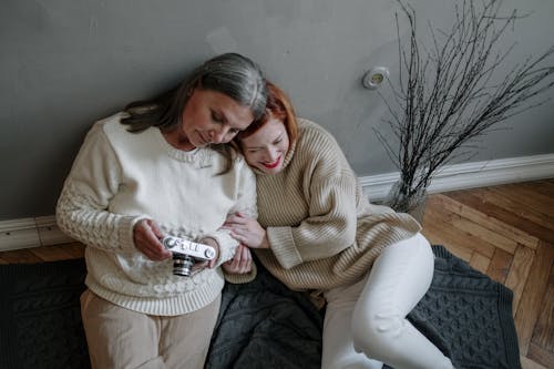 Two Women Leaning on Gray Wall