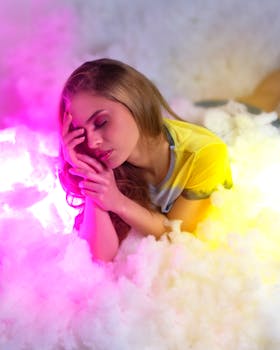 一位身着鲜艳服装的梦幻女性躺在亮紫色光芒的烟雾中