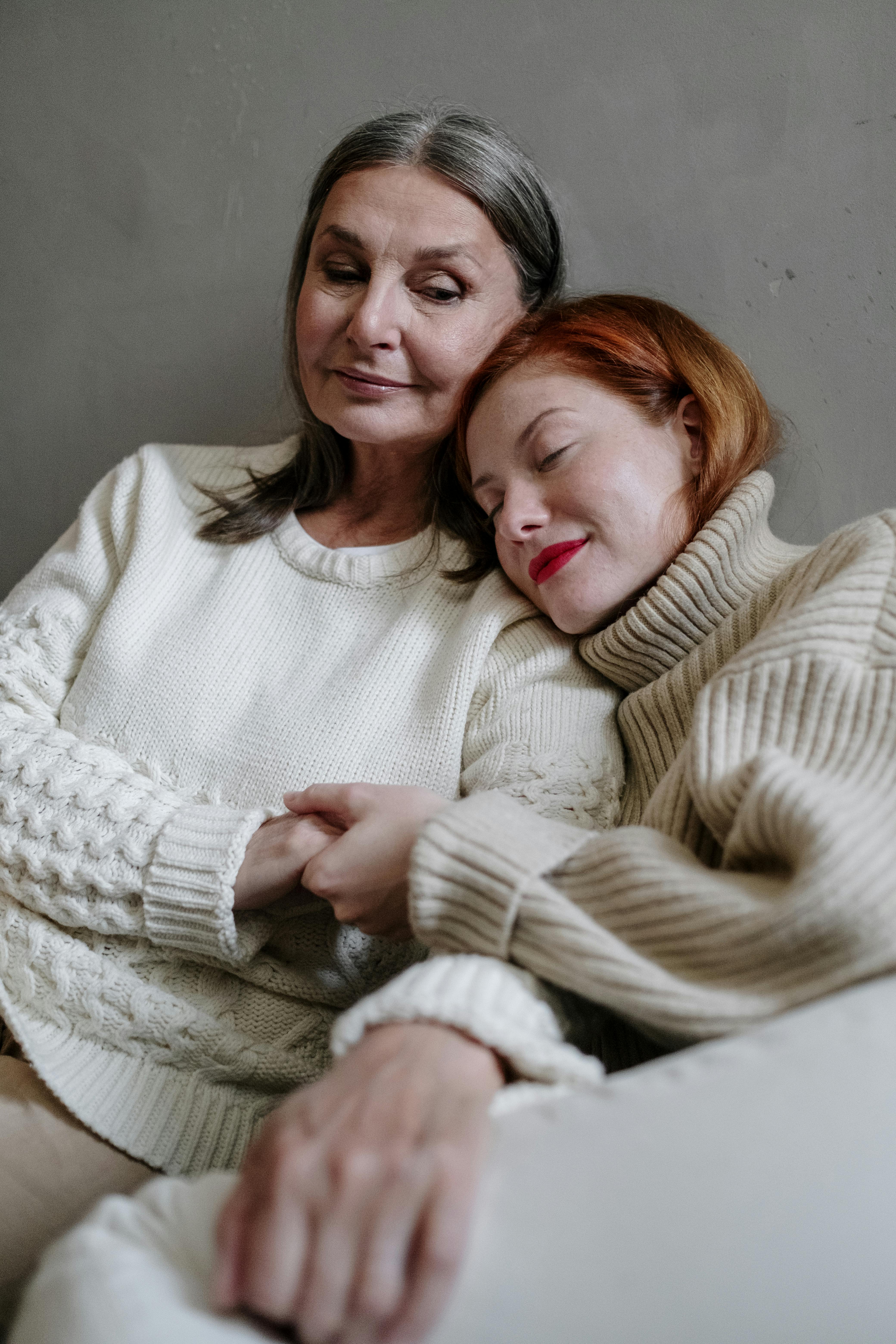 a daughter resting her head on her mother s shoulder