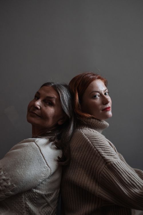 Free A touching portrait of two women back to back, expressing warmth and connection. Stock Photo