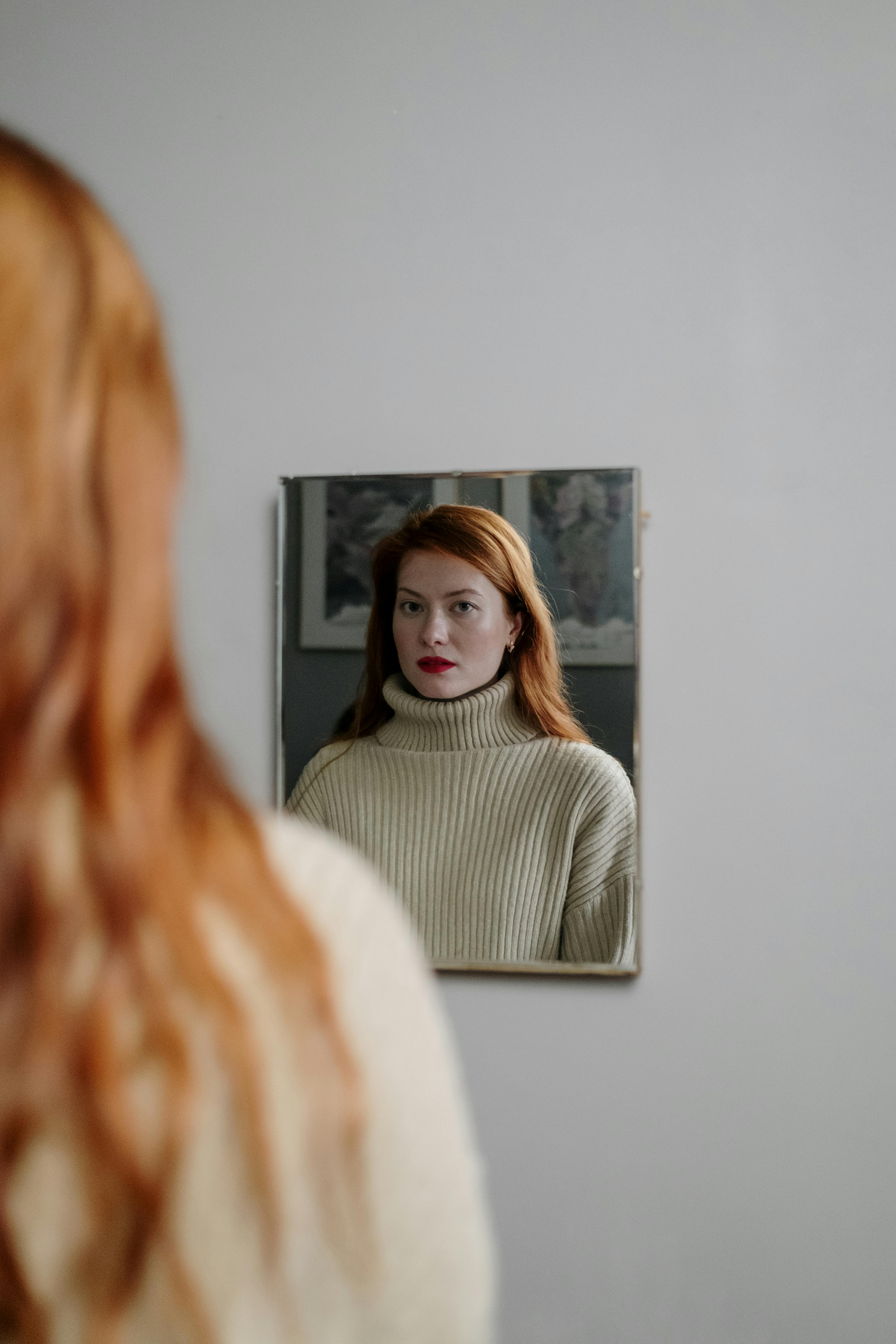 a woman in turtleneck sweater reflection on a mirror