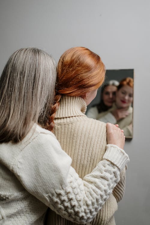 Free A Mother and Daughter Looking at Their Reflection in the Mirror Stock Photo