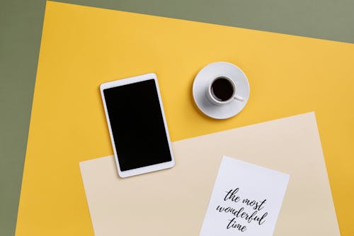 Free A Tablet and a Cup of Coffee on a Piece of Colored Paper Stock Photo