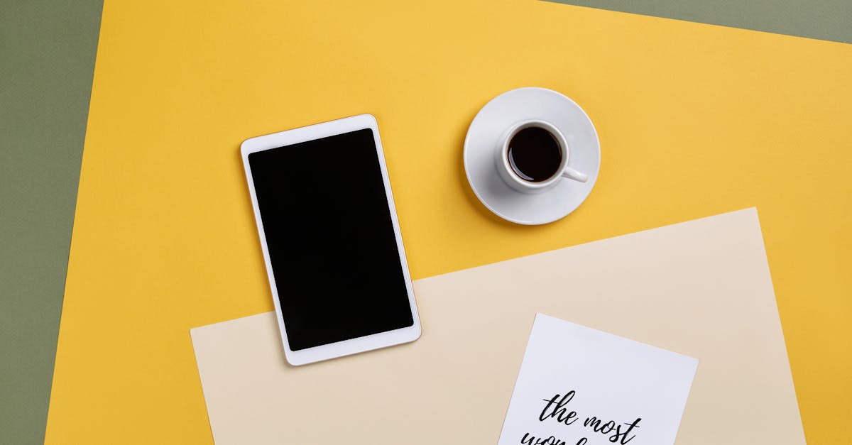 A top view of a minimalist office setup with a tablet, coffee, and paper.