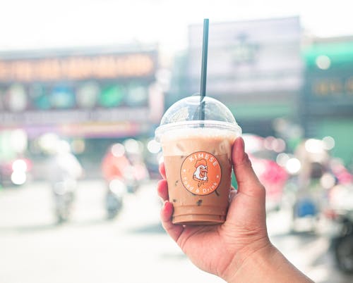 A Person Holding a Plastic Cup with Iced Coffee