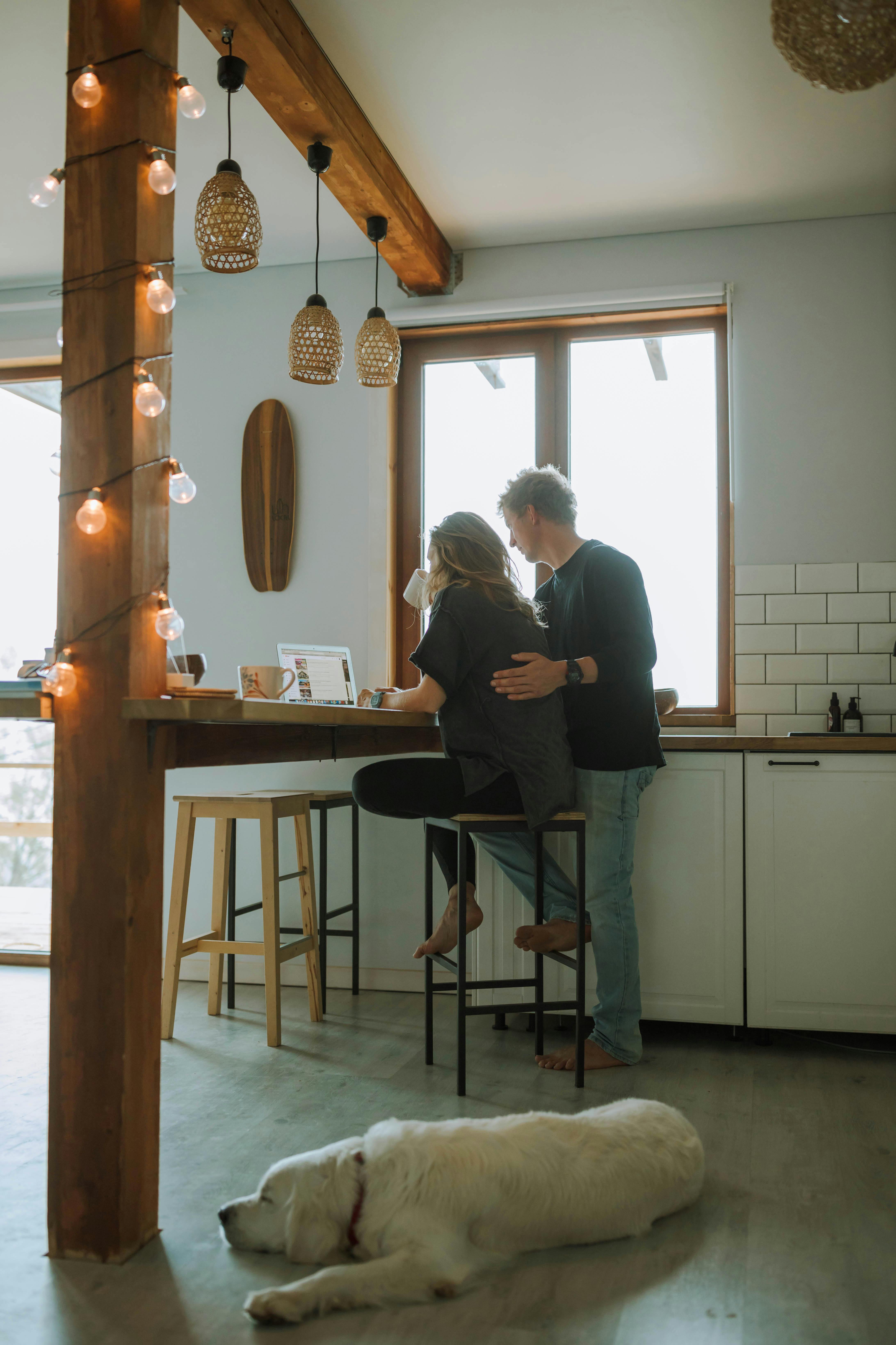 一对夫妇和他们的宠物狗在时尚的厨房里，享受着轻松的早晨