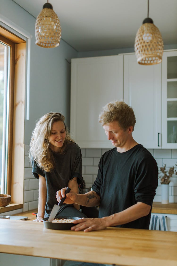 Man And Woman Cooking Together In The Kitchen