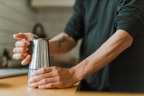 Free Close-Up Photo of a Person Holding a Stainless Steel Pitcher Stock Photo