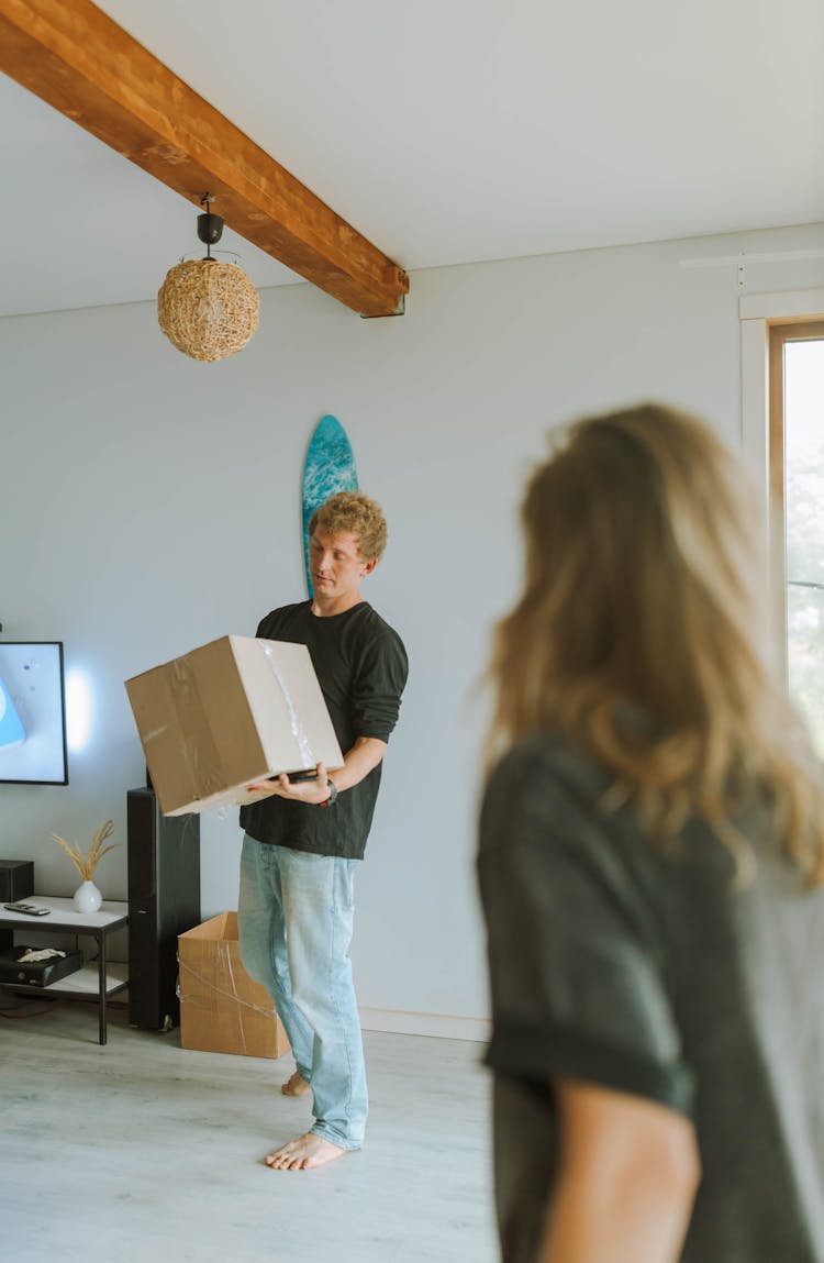 Man Carrying A Box Inside The House