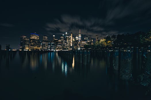 Captivating long exposure of New York City's skyline reflecting on the calm water at night.