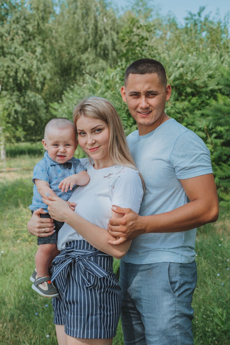 Cheerful Young Family With Baby Resting In Nature