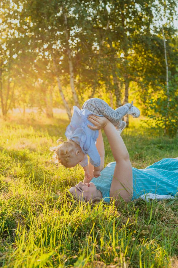 Father lifting his child playfully in the grass