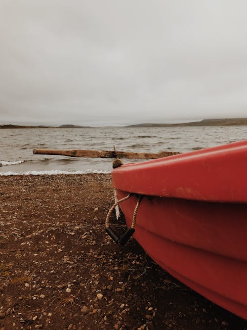 免費 紅色和棕色小船在海灘岸邊 圖庫相片