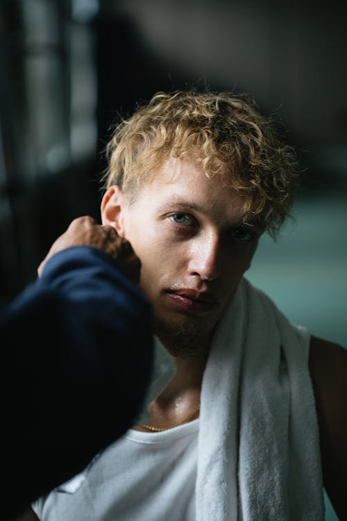 Free Handsome sportsman with wet face and towel on neck resting after workout and looking at camera Stock Photo