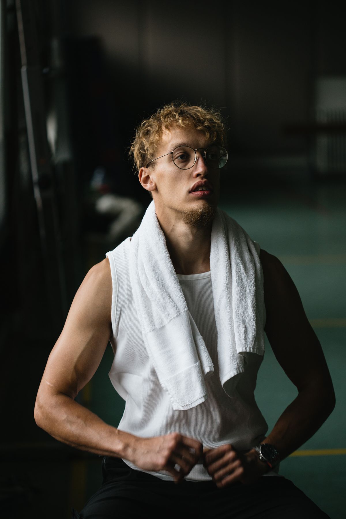 Muscular sportsman resting between sets at the gym