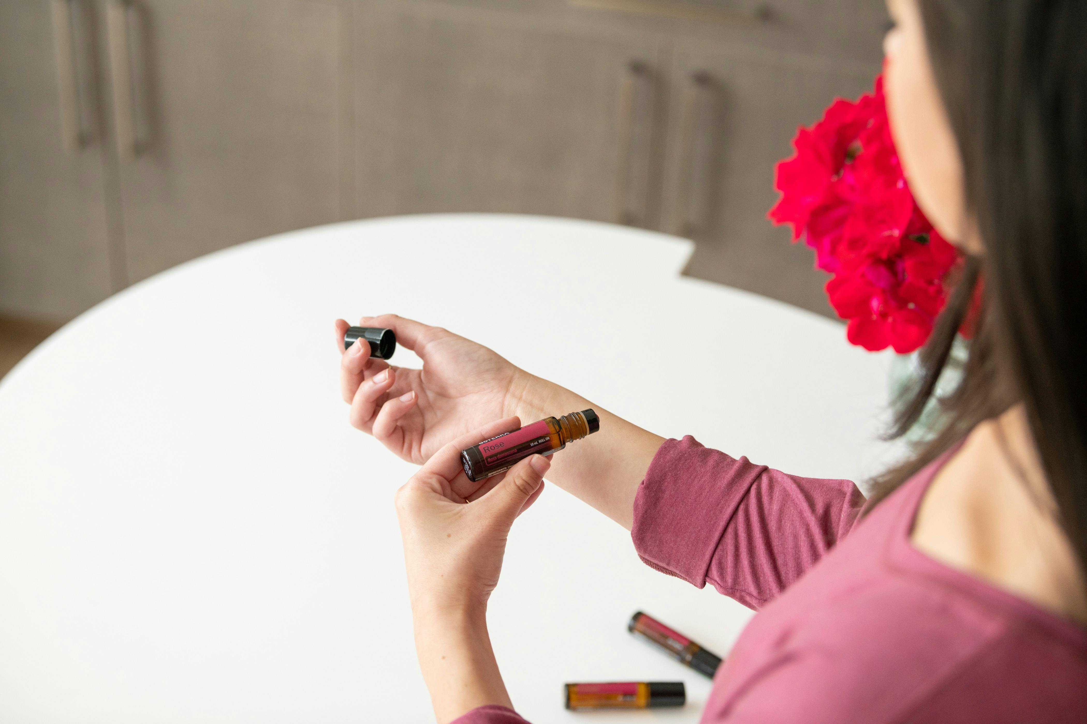 Free Woman Wearing a Pink Blouse Testing Essential Oils on the Skin Stock Photo