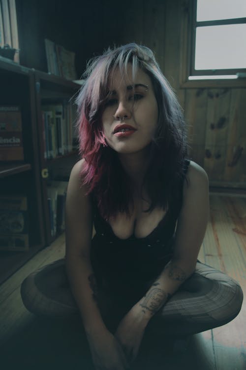 Beautiful Woman with Pink Hair near the Bookcase