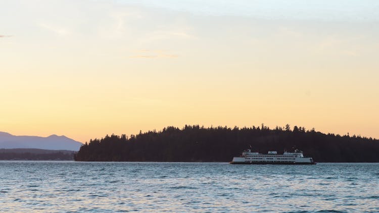 Scenic View Of A Ferry Cruising In The Sea Near The Island