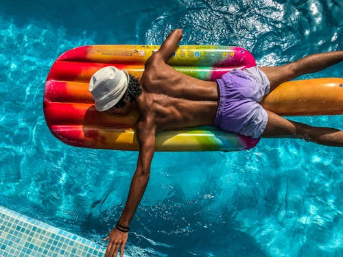 Free Man Wearing Shorts Lying on a Inflatable Floater Stock Photo