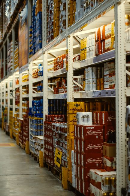 Rows of beer and beverages stacked neatly in a supermarket aisle. Rows of beer and beverages stacked neatly in a supermarket aisle.