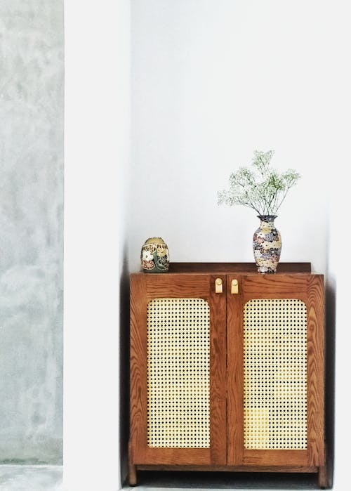 Brown Wooden Cabinet With Flower Vase on Top