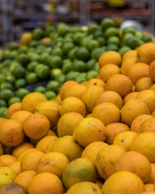 Free Vibrant oranges and limes on display at a bustling Brazilian market stall. Stock Photo