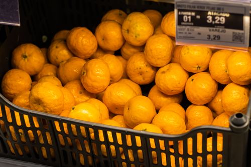 Free Bright oranges neatly stacked in a Brazilian supermarket, highlighting freshness and abundance. Stock Photo
