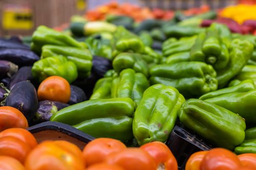 Free A vibrant assortment of fresh vegetables including bell peppers, tomatoes, and eggplants at a Brazilian market. Stock Photo