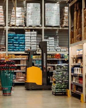 A warehouse with stacked goods, shelves, and a forklift in Brazil.